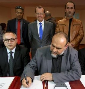 United Nations Special Representative and Head of the U.N. Support Mission in Libya Martin Kobler looks on as representatives of Libyan municipalities sign documents to support Libya's new national government.